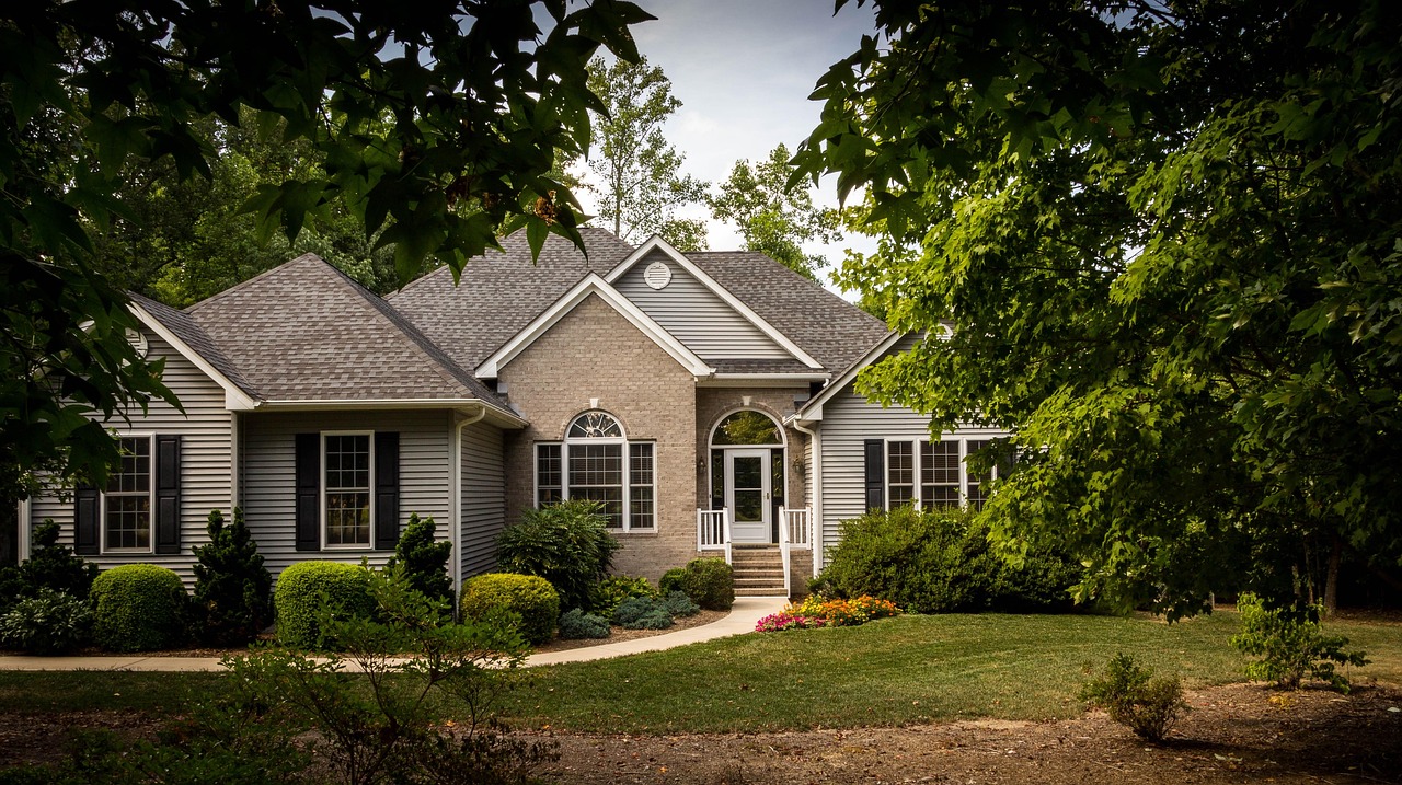 Brick house with a green front lawn and trimmed shrubs